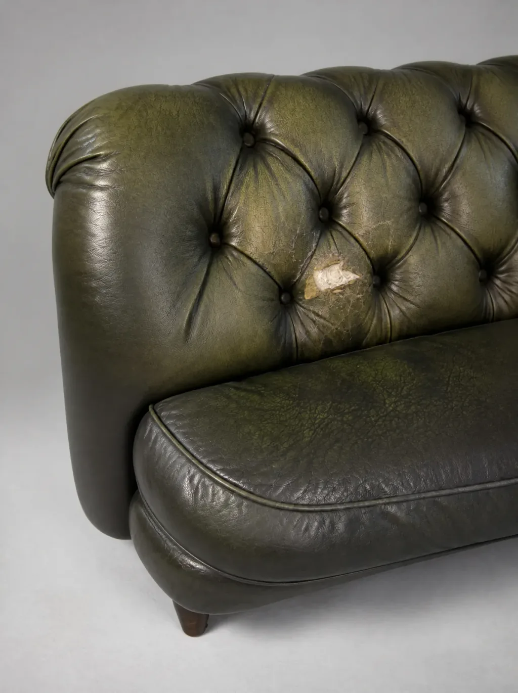 Ledersofa Reparatur in Wetzikon: Derselbe Schaden aus anderer Perspektive, mit feinem Maschenriss im Umfeld, Chesterfield Polstergruppe