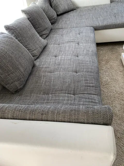 Die Sitzseite mit den verletzten Lederelementen unterhalb der Polster: Ecksofa mit Ledersockel in der Werkstatt, Neubezug Wetzikon